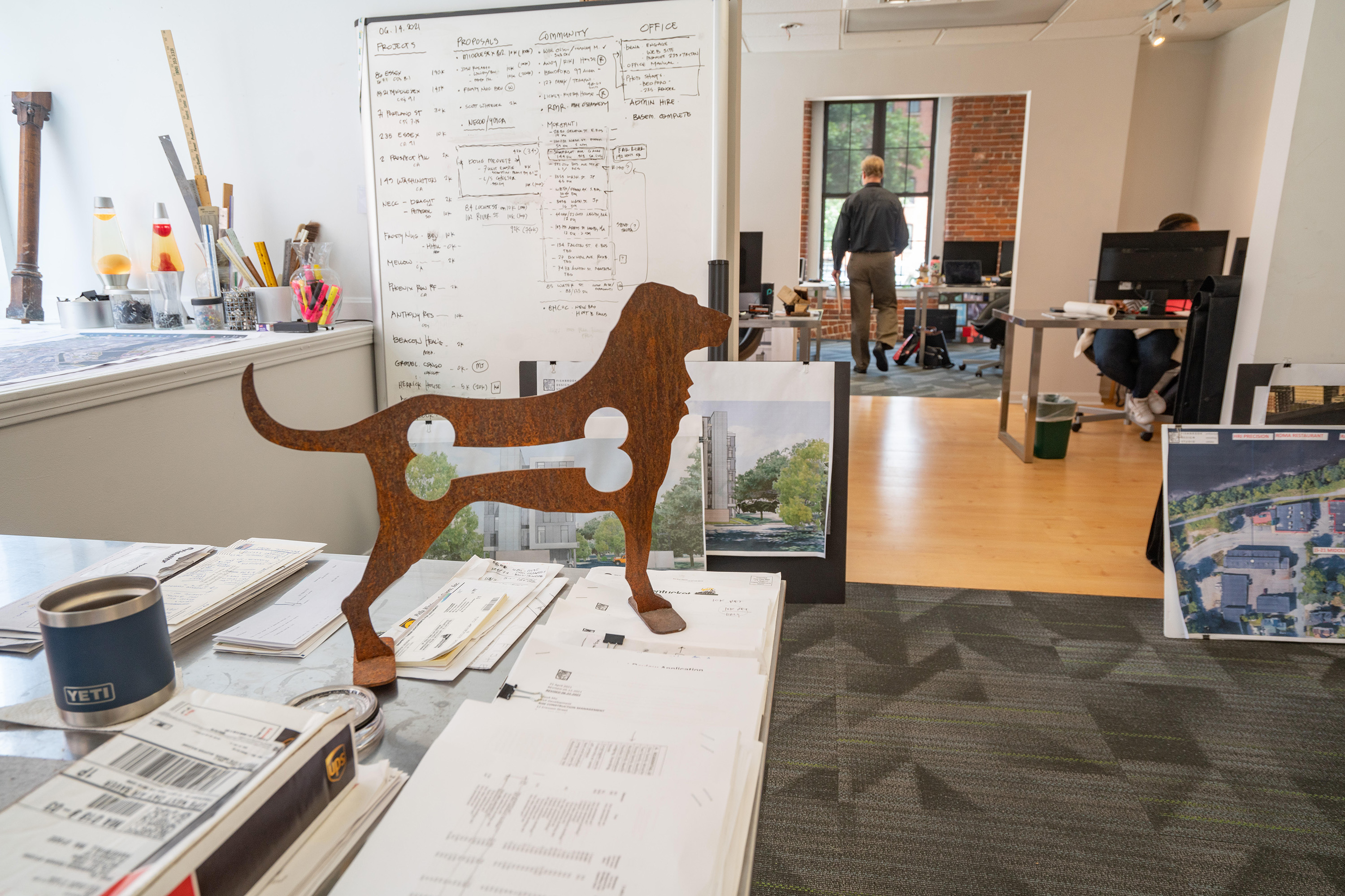 Inside the busy office, particularly focused on an interesting dog sculpture